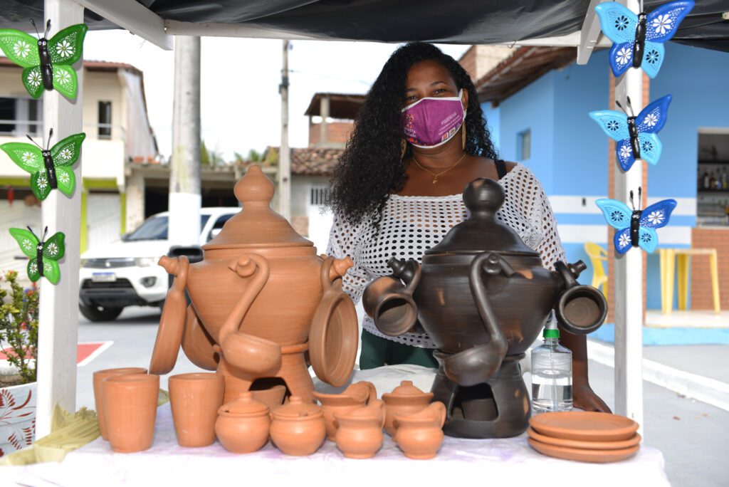 Mãos de um artesão trabalhando em um projeto para vender e ganhar renda extra.
